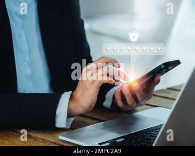 Zwei-Stufen-Authentifizierung (2FA) Konzept. 2023, Code der Shield- und Sternchensymbole, die auf dem Smartphone angezeigt werden, während der Computer zur Validierung des Kennworts verwendet wird Stockfoto