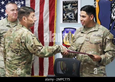 U.S. Army PFC. Antonio Mora, Spezialist für automatisierte Logistik, 92A, für Alpha Company, 449. Aviation Support Bataillon, 36. Combat Aviation Brigade, „Task Force Mustang“, 36. Infanterie Division (rechts), erhält Glückwünsche von Col. Scott P. Nichola, Kommandant der Task Force Mustang, Als er sein Leistungszertifikat als „Held der Woche“ der Brigade während eines Befehls- und Mitarbeitertreffens im Hauptquartier der Task Force Mustang, Camp Buehring, Kuwait, erhielt, 12. Oktober 2022. Mora, gebürtiger Laredo, Texas, wurde für seine Aufgaben außerhalb seines primären MOS, an denen accura beteiligt war, anerkannt Stockfoto