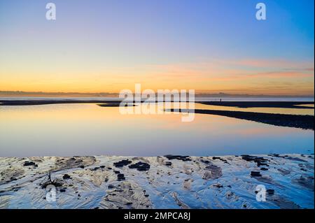 Einsamer Angler am Cleveleys Beach in der Abenddämmerung im Winter Stockfoto