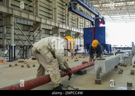 (230131) -- ZHUHAI, 31. Januar 2023 (Xinhua) -- Mitarbeiter legen Pipelines aus, bevor sie Beton in den Tauchschlauch E23 des Shenzhen-Zhongshan Highway Underwater Tunnels in einer Tauchrohrfabrik von CCCC Fourth Harbour Engineering Co., Ltd. Auf Niutou Island, Zhuhai, Provinz Guangdong in Südchina, 31. Januar 2023. Die Vorfertigung von E23, dem letzten Tauchrohr (nicht standardisiertes Rohr, einschließlich des letzten Gelenks) eines Unterwassertunnels, eines Abschnitts der Autobahn zwischen Shenzhen und Zhongshan in Guangdong, wurde am Dienstag abgeschlossen. Nach dem Gießen von Beton hat der 164,5 Meter hohe Stahlschalen TU Stockfoto