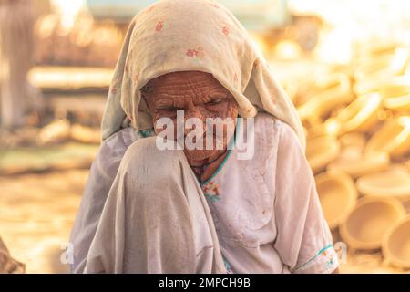 Karatschi Pakistan 2018, eine alte arbeiterfrau, die in seinem kleinen Laden sitzt, wo sie morgens Töpferarbeiten macht, Frauenförderung Stockfoto