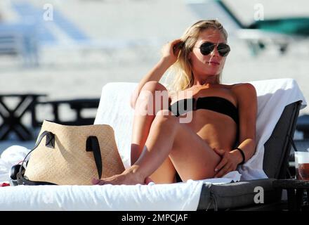 Der deutsche Fußballstar Bastian Schweinsteiger und die Freundin Sarah Brandner verbringen während ihres Urlaubs in Miami einen gemeinsamen Tag am Strand. Die beiden liegen am Meer und spielen zusammen in der schweren Brandung. Miami Beach, Florida 6/1/11. Stockfoto