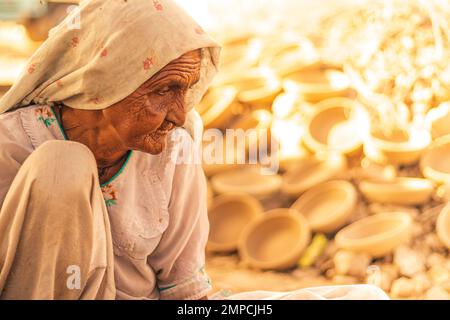 Karatschi Pakistan 2018, eine alte arbeiterfrau, die in seinem kleinen Laden sitzt, wo sie morgens Töpferarbeiten macht, Frauenförderung Stockfoto