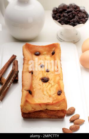 Gebackener Klappertaart, Manado Custard Cake mit holländischem Einfluss. Hergestellt aus Mehl, Kokosnuss, Ei, Zucker und Butter. Garniert mit Rosinen und Zimtpulver Stockfoto