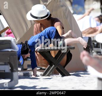 Sharlely Becker spielt mit ihrem Sohn Amadeus im Sand. Das abenteuerlustige Kleinkind stürzte fast von einem Tisch in den Sand, aber danach lächelte es alle. Miami Beach, Florida 26. Dezember 2011 Stockfoto