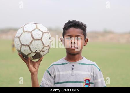 Karatschi Pakistan 2019, ein Kind, das am Sonntagmorgen mit seinem blauen Fußball für ein Foto posiert, asiatische Kinder, lokale Sportarten, Fußball in Pa Stockfoto