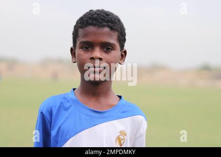 Karatschi Pakistan 2019, ein Kind, das am Sonntagmorgen mit seinem blauen Fußball für ein Foto posiert, asiatische Kinder, lokale Sportarten, Fußball in Pa Stockfoto