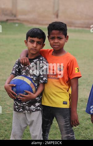 Karatschi Pakistan 2019, ein Kind, das am Sonntagmorgen mit seinem blauen Fußball für ein Foto posiert, asiatische Kinder, lokale Sportarten, Fußball in Pa Stockfoto