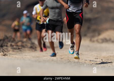 Laufschuhe für Läufer beim Traillauf. Die Beine von Ultra-Running-Athleten nähern sich dem Laufen auf dem Rock Path Trail Stockfoto