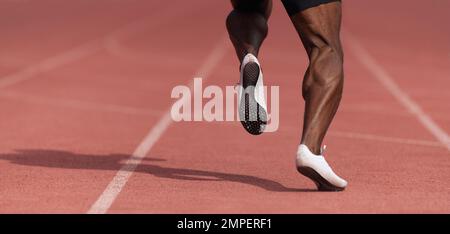 afroamerikanischer männlicher Sportler, der auf einer Stadionstrecke läuft, dynamischer Sprinter-Lauf in einem Stadion Stockfoto