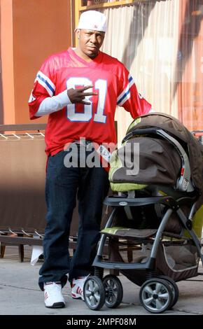 Papa Bobby Brown wartet in einem Parkservice in Beverly Hills auf sein Fahrzeug und zeigt ein Friedenszeichen, wenn er mit dem Kinderwagen seines Babys steht. Brown wurde Ende Mai wieder Vater, als Alicia Etheridge das erste gemeinsame Kind des Paares zur Welt brachte. Los Angeles, Kalifornien. 11/12/09. Stockfoto
