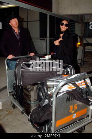 Exklusiv!! Tennischampion Boris Becker und Sharlely Kerssenberg kommen nach einem Auslandsflug am Miami International Airport an. Die beiden posierten für Fotos und machten sich auf den Weg zu einem wartenden Fahrzeug. Boris half einem Gepäckträger, sein Gepäck, einschließlich einiger seiner Signaturtaschen, in das Fahrzeug zu laden, bevor sie losfuhren. Miami, Florida 3/28/09. Stockfoto