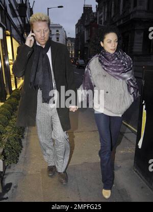 Der deutsche Tennis-Superstar Boris Becker chattet auf seinem Handy, während er mit seiner Frau Sharlely Kerssenberg in Mayfair spaziert. London, Großbritannien. 2/2/11. Stockfoto