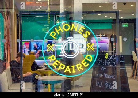 ee-Telefone kaufen Fenster von der Straße mit reparierten Telefonen und Breitbandangeboten Stockfoto