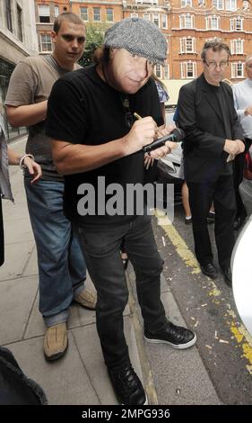 EXKLUSIV!! Leadsänger der legendären Rockband AC/DC Brian Johnson signiert Autogramme für wartende Fans vor dem BBC Radio Studio. Johnson schaute unter seiner grauen Fahrerkappe heraus und lächelte für die Kamera. Als er gefragt wurde, ob er neben dem neuen Ferrari von BBC Radio 2 DJ Chris Evans posieren würde, sagte er angeblich scherzhaft: „Bei allem Respekt, warum sollte ich vor dem Auto eines anderen posieren wollen? Ich habe heute einen neuen Ferrari gekauft. London, Großbritannien. 07/29/10. Stockfoto