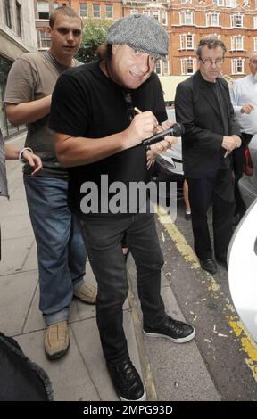 EXKLUSIV!! Leadsänger der legendären Rockband AC/DC Brian Johnson signiert Autogramme für wartende Fans vor dem BBC Radio Studio. Johnson schaute unter seiner grauen Fahrerkappe heraus und lächelte für die Kamera. Als er gefragt wurde, ob er neben dem neuen Ferrari von BBC Radio 2 DJ Chris Evans posieren würde, sagte er angeblich scherzhaft: „Bei allem Respekt, warum sollte ich vor dem Auto eines anderen posieren wollen? Ich habe heute einen neuen Ferrari gekauft. London, Großbritannien. 07/29/10. . Stockfoto