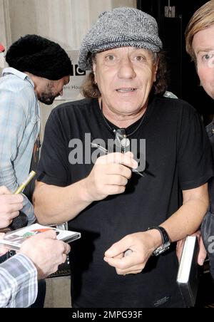 EXKLUSIV!! Leadsänger der legendären Rockband AC/DC Brian Johnson signiert Autogramme für wartende Fans vor dem BBC Radio Studio. Johnson schaute unter seiner grauen Fahrerkappe heraus und lächelte für die Kamera. Als er gefragt wurde, ob er neben dem neuen Ferrari von BBC Radio 2 DJ Chris Evans posieren würde, sagte er angeblich scherzhaft: „Bei allem Respekt, warum sollte ich vor dem Auto eines anderen posieren wollen? Ich habe heute einen neuen Ferrari gekauft. London, Großbritannien. 07/29/10. . Stockfoto