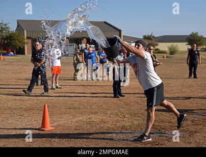 James DeAnda, 17. Civil Engineer Squadron's „poor Choice“ Team Member, wirft Wasser während der jährlichen Fire Muster Challenge am Goodfellow Air Force Base, Texas, am 14. Oktober 2022. Wasser aus einem Eimer zu werfen, stellte dar, wie Feuerwehrmänner in der Vergangenheit Brände löschten. Stockfoto