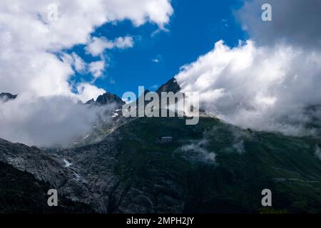 Blick von Gletsch auf den Furka Pass und die Gipfel der Berge Furkahorn und Galenstock. Stockfoto