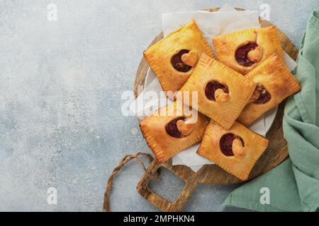 Valentinstag herzförmige Handkuchen. Mini-Blätterteig oder Handkuchen gefüllt mit Apfel und streuen Sie Zuckerpulver auf den Teller. Eine Idee für hausgemachte Romantiker Stockfoto