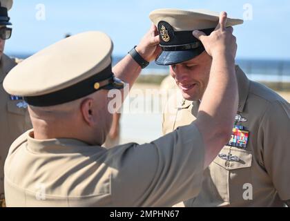 CORONADO, Kalifornien (21. Oktober 2022) Chief Information Systems Technician Dustin Hall, dem Naval Special Warfare Tactical Communications Command 1 zugeteilt, erhält während einer Festpinnungszeremonie im Silver Strand Training Complex die Deckung seines leitenden Petty Officers. Naval Special Warfare ist die landesweit führende Spezialeinsatztruppe für die Seeschifffahrt. Sie ist einzigartig positioniert, um die Reichweite der Flotte zu erweitern und Marinekommandeure und Kommandeure der gemeinsamen Einsatzkräfte mit allen Domänen auszustatten. Stockfoto