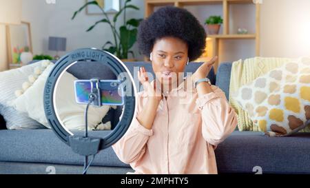 Weibliche Beeinflusserin und Vloggerin, die Inhalte auf einem Telefon zu Hause aufzeichnen. Junger YouTuber, der online live für einen Vlog-Kanal streamt. Während ich einen Podcast filme Stockfoto