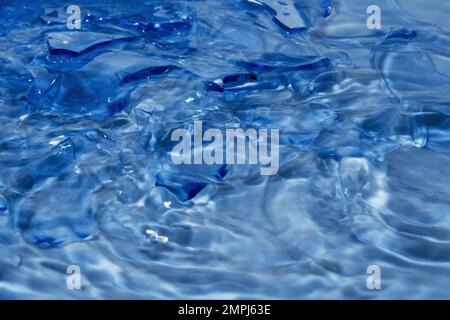Blauer Hintergrund. Wasser und Glas. Stockfoto