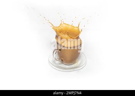 Kronenspritzer auf einer transparenten Kaffeetasse aus Glas mit Milch, isoliert auf weißem Hintergrund Stockfoto