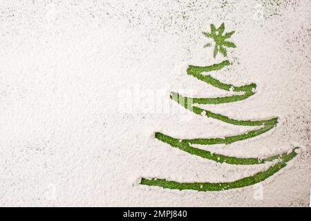 Weihnachtsbaum-Fingerzeichen, auf Puderzucker, wenig Weihnachtsgeschichte Stockfoto