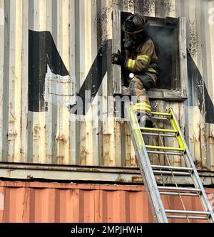 Ein Feuerwehrmann, der der Feuerwehr von Duluth zugewiesen wurde, verlässt am 27. Oktober 2022 während einer Live-Brandentwicklung im Emergency Response Training Center der Lake Superior College, Duluth, Minnesota, einen Strukturbrand. Die Feuerwehr 148., die Feuerwehr Duluth und die höhere Feuerwehr haben gemeinsam einen zweiwöchigen, praktischen Abschlusskurs veranstaltet, der den neuen Feuerwehrleuten helfen soll, in ihrer neuen Karriere erfolgreich zu sein und Trainingspläne für die Feuerwehr in der Region zu standardisieren. (Foto der Air National Guard von Audra Flanagan) Stockfoto