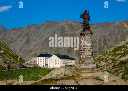 Die Statue von St. Bernard, Gebäude und alpine Landschaft auf dem Great St. Bernard Pass. Stockfoto