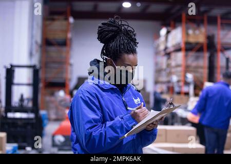 Aviation Maintenance Administrationman 1. Klasse Kelsy Jones, zugewiesen zu den ‚Spartanern‘ des Helicopter Maritime Strike Squadron 70 (HSM 70), an Bord des Ticonderoga-Klasse-Guided-Raketenkreuzers USS Normandy (CG 60), überprüft ein Verzeichnis gespendeter Nahrungsmittel während einer Community Relations Veranstaltung in Feed Nova Scotia in Halifax, Kanada, 1. Nov. 2022. Der erstklassige Flugzeugträger USS Gerald R. Ford (CVN 78) befindet sich in seinem ersten Einsatz und führt neben den NATO-Alliierten und -Partnern Schulungen und Operationen durch, um die Integration für zukünftige Operationen zu verbessern und die USA zu demonstrieren Kommunikation der Navy Stockfoto