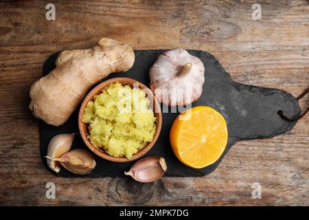 Frischer Knoblauch und andere natürliche kalte Heilmittel auf Holztisch, Draufsicht Stockfoto