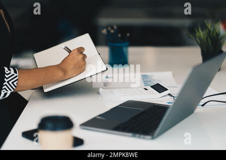 Schöne asiatische Geschäftsfrau, die sich das pädagogische Webinar auf einem Laptop ansieht. Finanzierungskonzept. Stockfoto