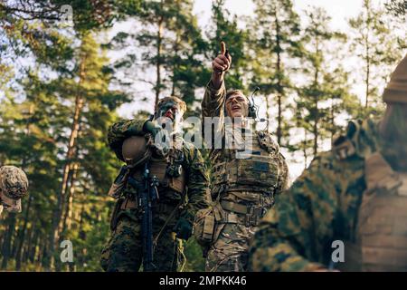 USA Marine Corps Sgt. Kevin Hackman, ein Joint Terminal Attack Controller, mit Combat Logistics Battalion 6 (CLB-6), Combat Logistics Regiment 2, 2. Marine Logistics Group, mit britischen Soldaten, von 2 Gewehren Mörtelzug beobachtet Mörserfeuer während eines finnischen Mörtelrufs in Syndalen, Finnland, November 1 2022. Die Task Force Red Cloud mit Hauptsitz von Elements des CLB-6 wird nach Finnland entsandt, um die Übungen SYD 2022 und Freezing Winds 2022 zu unterstützen, um die gegenseitige Abhängigkeit der USA und Finnlands im maritimen Bereich zu stärken und bilaterale maritime Manöver innerhalb der finnischen Küstenlandschaft zu festigen Stockfoto