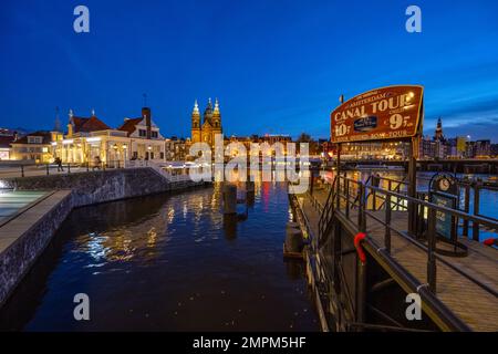 Blick über den Hafen auf die Prins Hendrikkade Straße von der Vorderseite der Amsterdamer Centraal Station IJzijde. Stockfoto