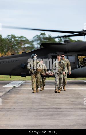 Soldaten, die der Task Force Orion, dem 27. Infanterie-Brigade-Kampfteam, der New Yorker Armee-Nationalgarde, der 12. Kampfluftfahrtbrigade und dem Joint Multinational Readiness Center zugeteilt sind, tragen während einer medizinischen Evakuierungsprüfung in Grafenwoehr, Deutschland, am 3. November 2022 eine militärische Übungspuppe von einem UH-60 Black Hawk-Hubschrauber weg. Die Task Force Orion wird seit August 2022 zur Unterstützung der Mission der Gemeinsamen multinationalen Ausbildungsgruppe – Ukraine eingesetzt, um die Wirksamkeit der Ausbildung ukrainischen Militärpersonals in unter dem Präsidenten der Vereinigten Staaten ausgestellten Systemen und Ausrüstungen im Kampf zu gewährleisten Stockfoto