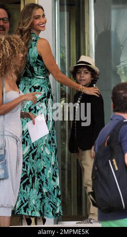 Sofia Vergara filmt Szenen mit Jon Favreau und Emjay Anthony in der Hitze im Fontainebleau Miami Beach Hotel. Vergara, die ein fließendes grünes Kleid trug, schien Spaß mit ihrem jungen Co-Star zu haben. Sie hielt zwischen den Szenen eine Hand auf seiner Schulter und brachte ihn zum Lachen und Lächeln. An einem Punkt nahm er auch seinen Arm, damit er den wartenden Paparazzi zuwinkte, zusammen mit Jon, der auch den Fotografen winkte. Miami Beach, Florida 12. August 2013. Stockfoto