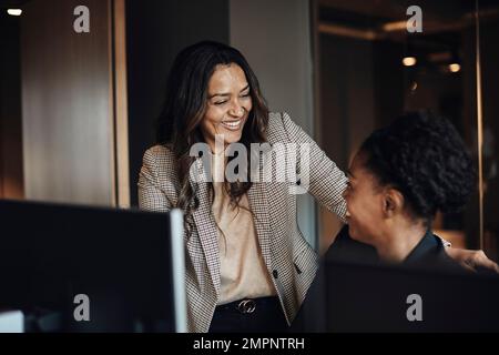 Glückliche weibliche Geschäftskollegen, die miteinander kommunizieren Stockfoto