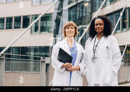 Porträt einer selbstbewussten multirassischen Ärztin, die vor dem Krankenhaus steht Stockfoto