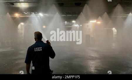 Joel Morgado, ein ziviler Inspektor der Küstenwache, beobachtet am 9. November 2022 in San Juan, Puerto Rico, einen Test des fest eingebauten wasserbasierten Feuerlöschsystems auf einem Frachtdeck eines Fährschiffs. Der Hafenstaatkontrollbeamte der Küstenwache (PSCO) überprüft, dass Schiffe unter ausländischer Flagge, die in US-Gewässern eingesetzt werden, den US-Gesetzen und den internationalen Vorschriften zum Schutz des menschlichen Lebens auf See entsprechen. (Foto von LT. j.g. Timothy Mutter, Küstenwache, Inspektor der San Juan Marine.) Stockfoto