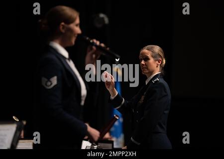 Capt. Christina Muncey, Right, Befehlshaber und Dirigent der United States Air Force Heritage of America Band, dirigiert die Heritage Band als Staff Sgt. Rachael Colman, United States Air Force Heritage of America Band Sängerin, singt während eines Veteran's Day-Konzerts am Edgecombe Community College in Tarboro, North Carolina, am 9. November 2022. Die Heritage of America Band ehrt alle, die in den Streitkräften der Vereinigten Staaten gedient haben, indem sie den Beiträgen der Veteranen der Nation gedenkt; Vergangenheit und Gegenwart, sowohl zu Hause als auch an stationierten Orten auf der ganzen Welt. Stockfoto