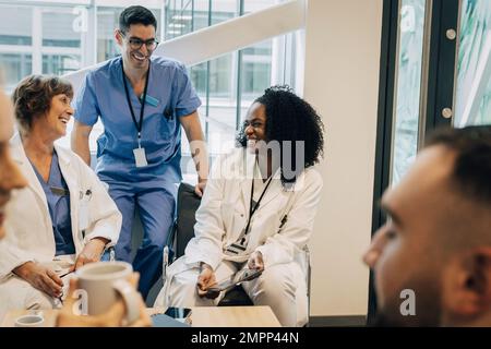 Glückliche multirassische Mitarbeiter im Gesundheitswesen während der Kaffeepause im Krankenhaus Stockfoto