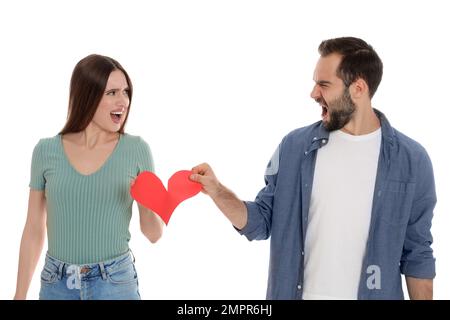 Ein Paar reißt das Papierherz auf weißem Hintergrund. Beziehungsprobleme Stockfoto