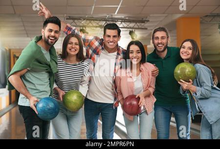 Eine Gruppe von Freunden mit Bällen im Bowling-Club Stockfoto