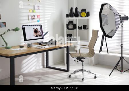 Arbeitsplatz des Fotografen mit professioneller Kamera und Computer im Büro Stockfoto