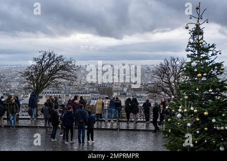 Paris, Frankreich - 5. Januar 2023: Touristen genießen den Blick auf Paris, Frankreich, von den Stufen der Basilika Sacré-Cœur während der Weihnachtszeit. Stockfoto