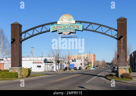 Anacortes, WA, USA - 29. Januar 2023; bogenförmiges Schild über der Straße, das das historische Stadtzentrum von Anacortes, WA, mit blauem Himmel und ohne Menschen begrüßt Stockfoto