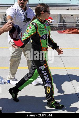 Die IndyCar-Fahrerin Danica Patrick, 28, signiert unauffällig Autogramme, während sie in ihrem Overall eine Boxenstraße entlang geht, nachdem sie ihr Nachmittagstraining vor dem Café do Brasil Indy 300 auf dem Homestead-Miami Speedway absolviert hat. Homestead, Florida. 10/01/10. Stockfoto