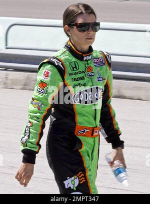 Die IndyCar-Fahrerin Danica Patrick, 28, signiert unauffällig Autogramme, während sie in ihrem Overall eine Boxenstraße entlang geht, nachdem sie ihr Nachmittagstraining vor dem Café do Brasil Indy 300 auf dem Homestead-Miami Speedway absolviert hat. Homestead, Florida. 10/01/10. Stockfoto